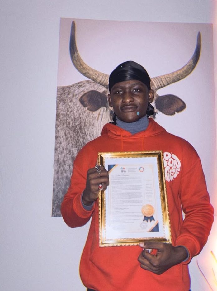 Tsotello Nenzinane holding latest award that he recieved.